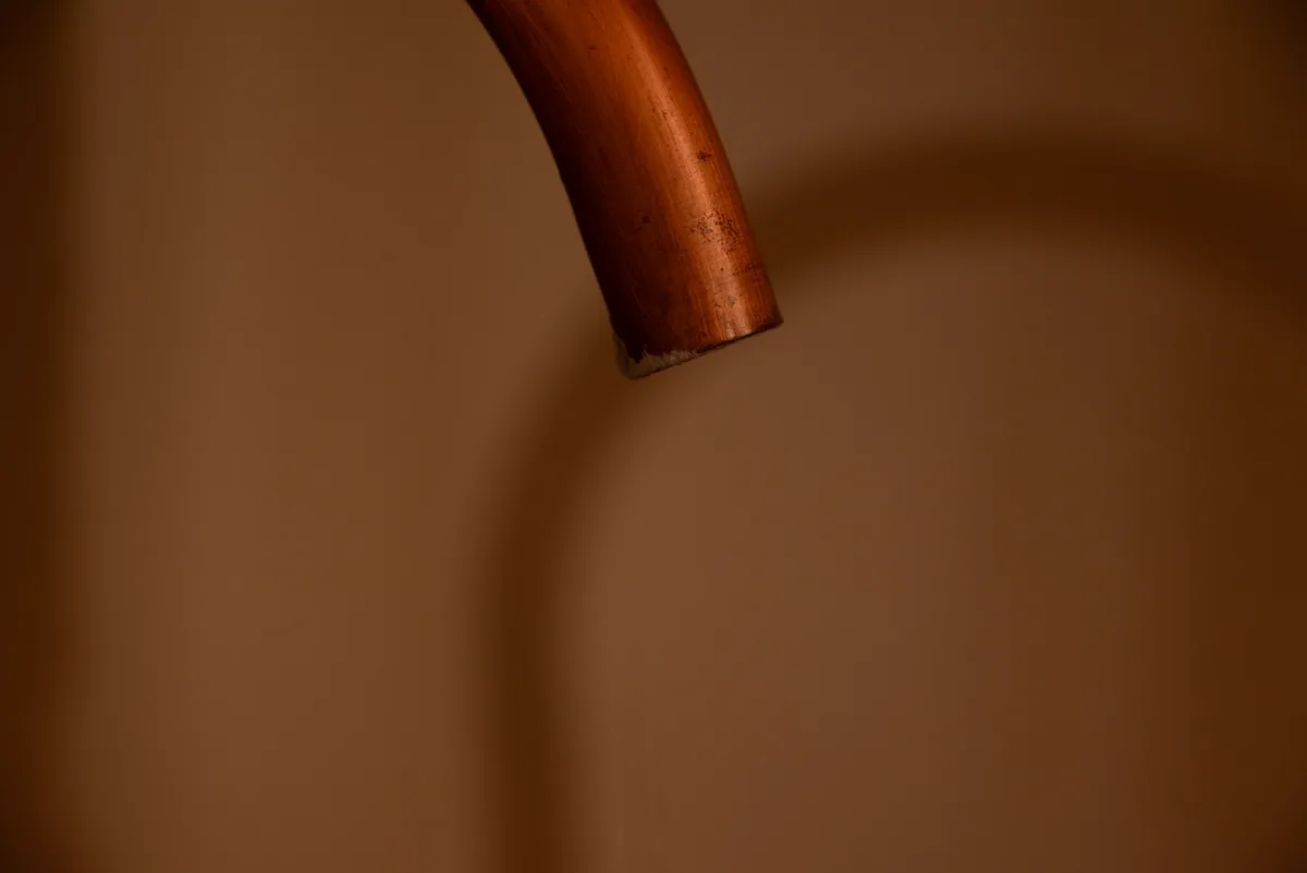Master plumber installing burst pipe repair equipment in a Florida home